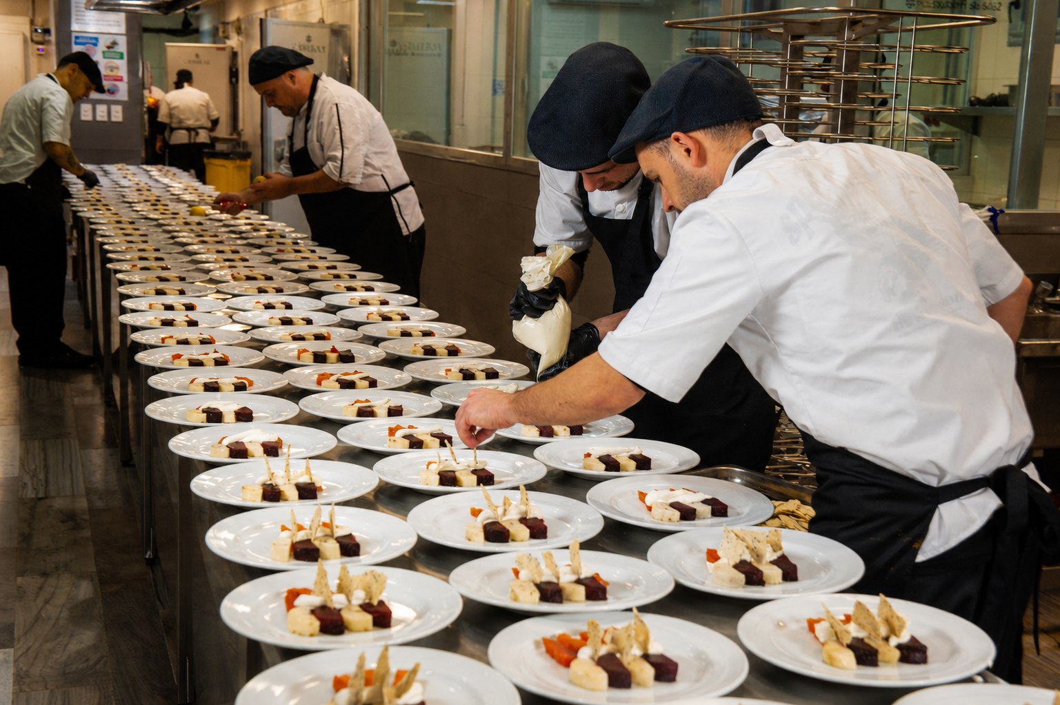 Equipo de cocina emplatando en línea para un evento de Vonharv